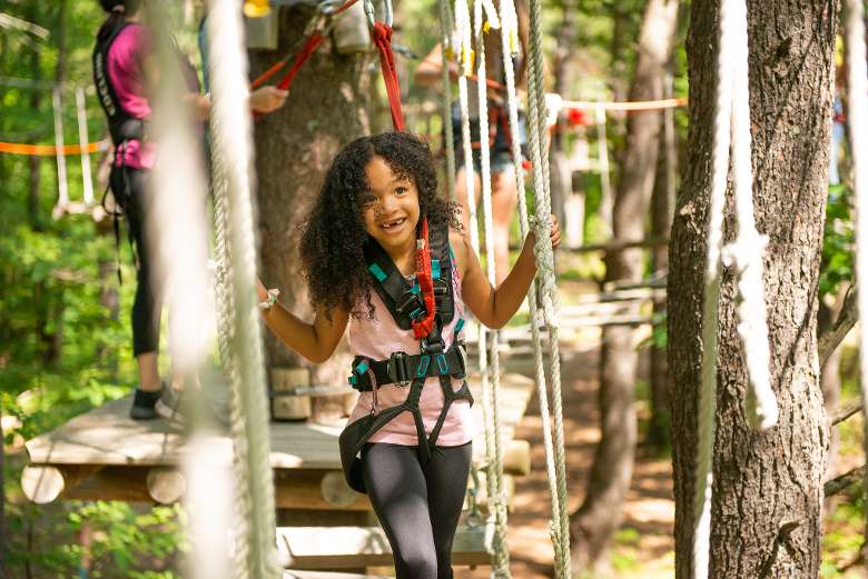 a young girl on a treetop course