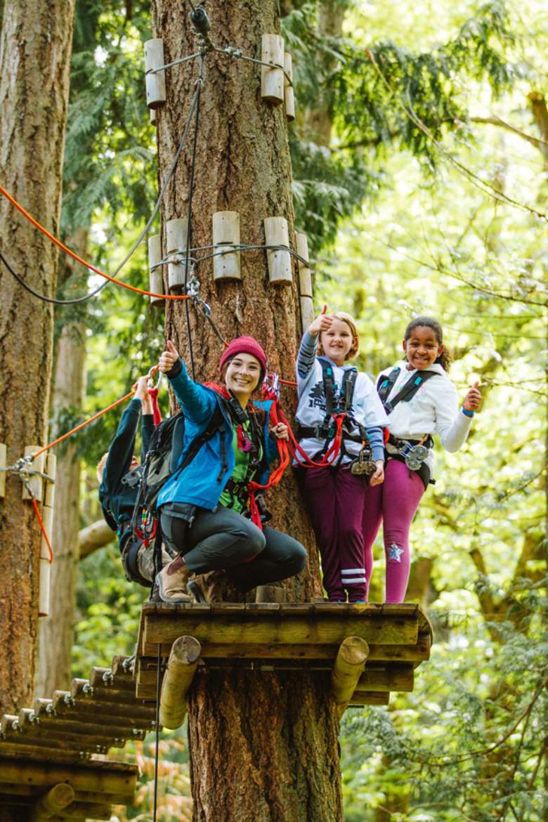 woman and two girls on a treetop course