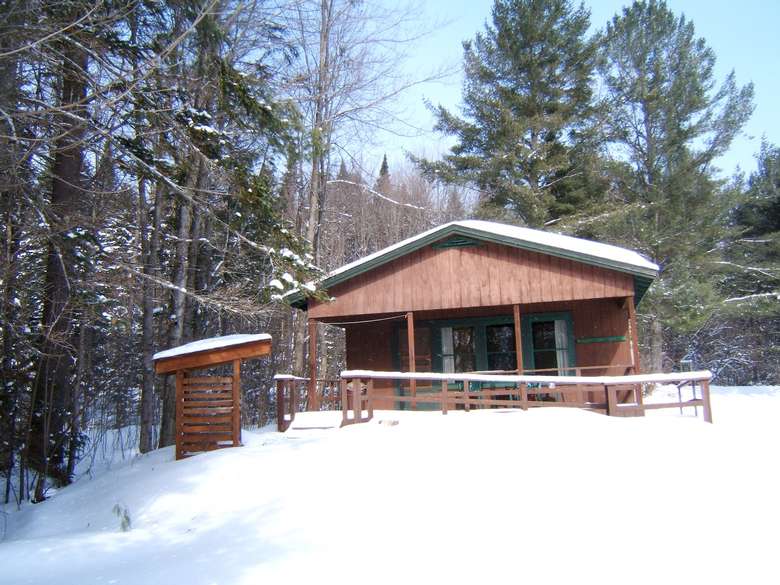 a cabin with snow on the ground during winter