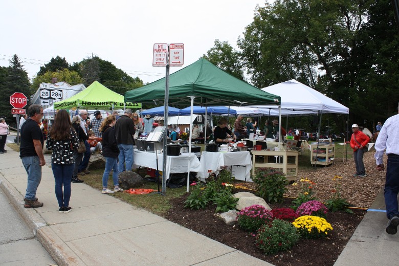 people walking by outdoor vendor tents