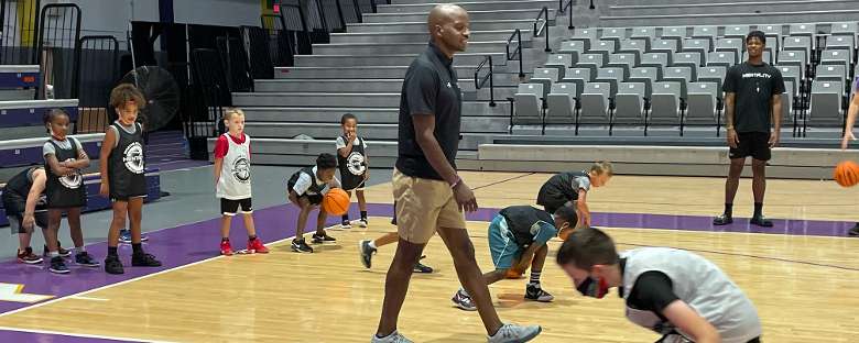 basketball coach and young kids on a court