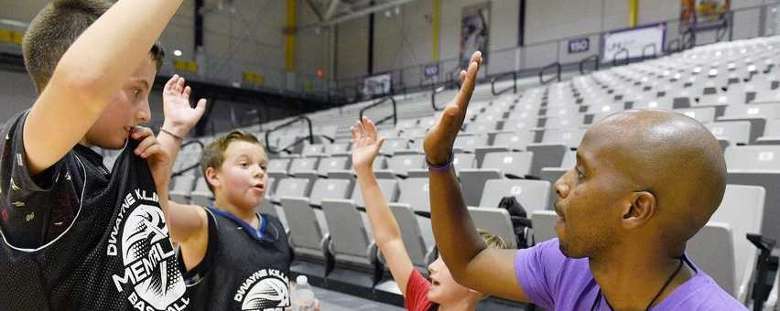 male basketball coach giving kids a high five