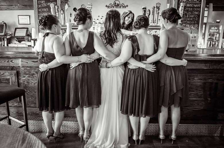 bridal party linking arms at a bar