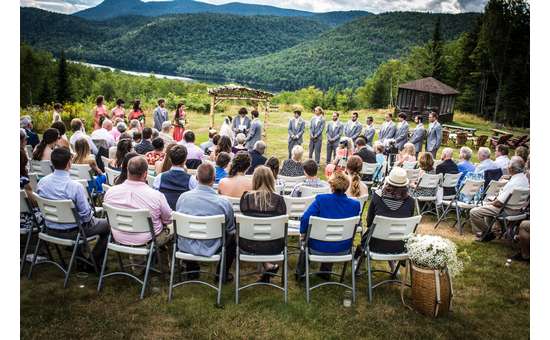 wedding guests seated for ceremony outdoors, mountains in background