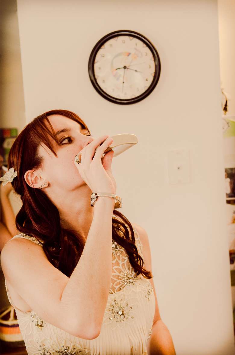 a bride drinking from a flask