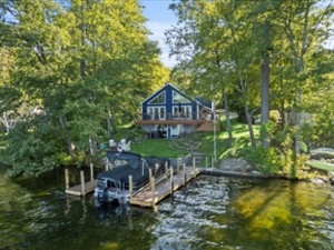 Lakeside view of the home. This home offers direct lake access with a sandy bottom, dock space for two boats (up to 27&prime; long).