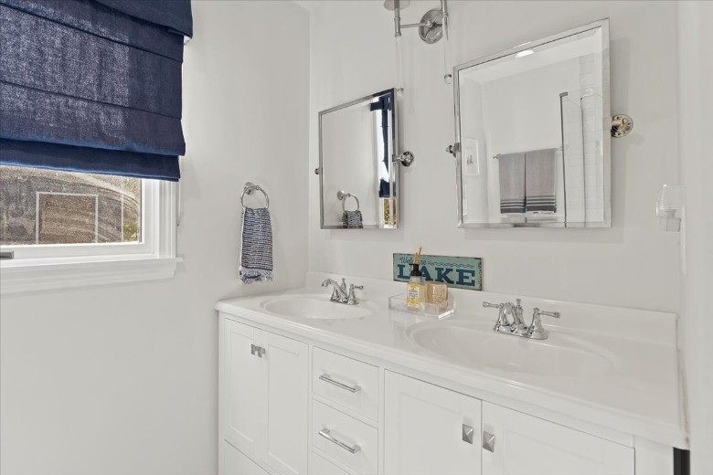 Main level bathroom with shower, and double sinks