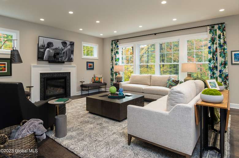 a spacious living room with white couches and colorful green decor