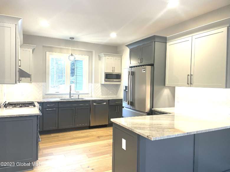 bright lights inside of a kitchen with gray cabinets