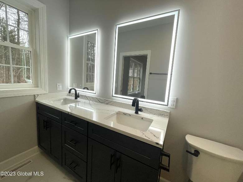 a bathroom sink with two faucets and mirrors