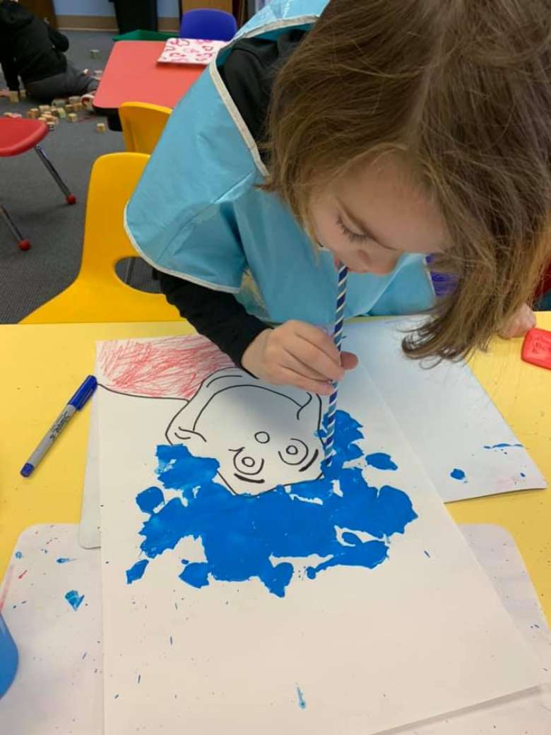 little girl painting Dr. Seuss picture