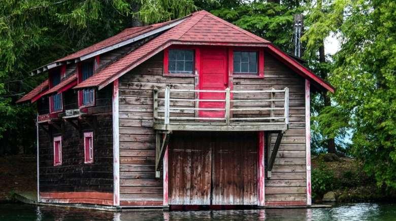 an old boathouse with a red roof