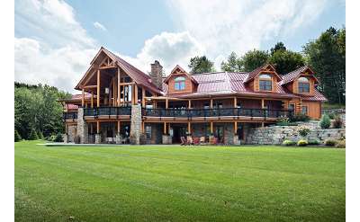 a large resort home with tall windows and wooden frame