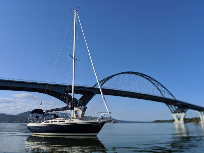sailboat with large bridge in the background