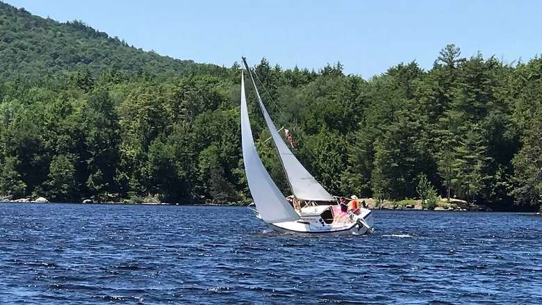 a sailboat turning on a lake