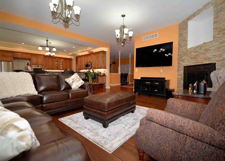 Living room with plenty of seating, 75-inch Smart TV, Sonos surround sound system, and fireplace