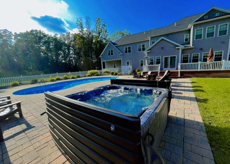 a house backyard with a pool and tub