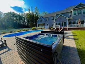 a house backyard with a pool and tub