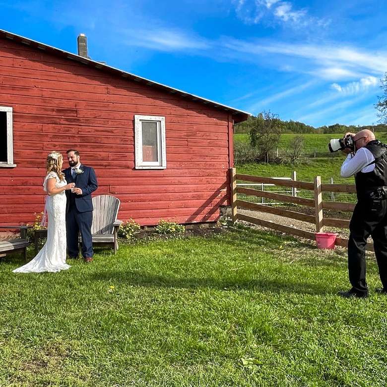 photographer with bride and groom on farm