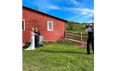 photographer with bride and groom on farm