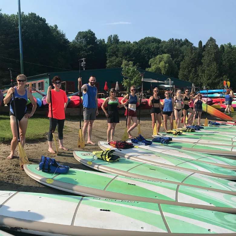 people standing in front of stand up paddleboards