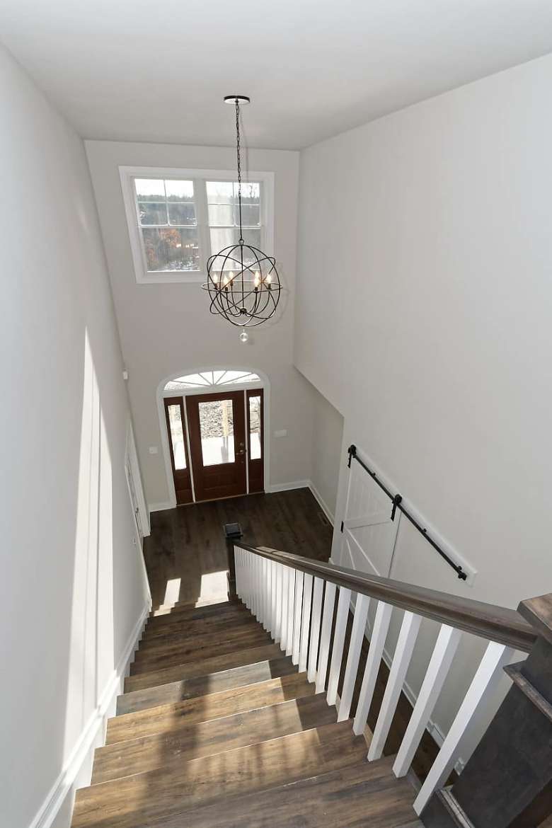 view from the top of a staircase in a house with white walls