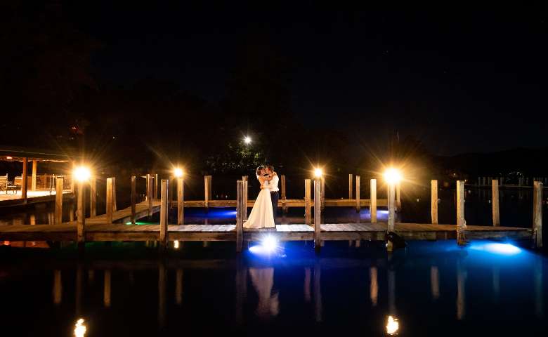 bride and groom on a boat dock at night