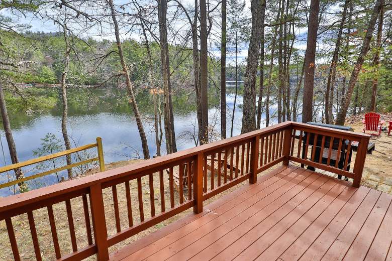 deck connected to a house with view of the lake nearby