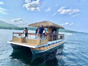 people on a tiki boat on a lake