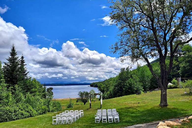 view of lake, seating, and wedding arch