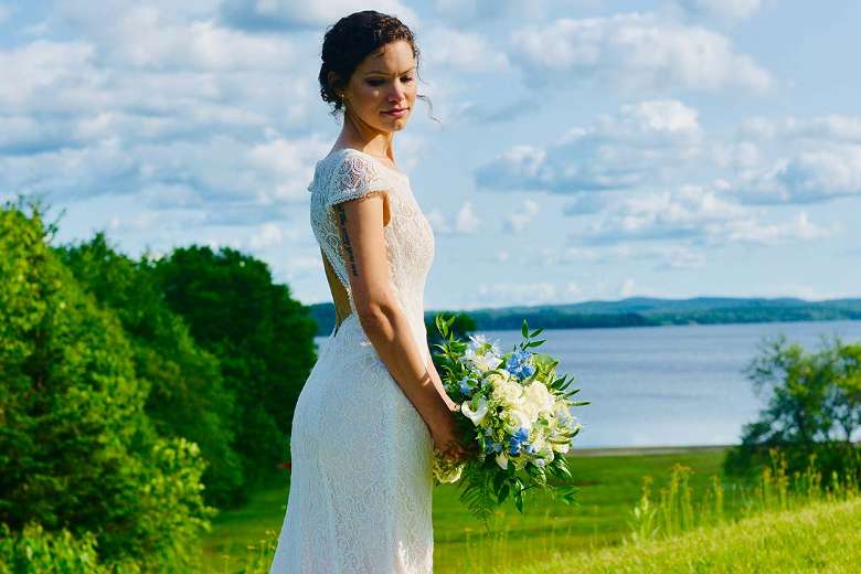 bride standing with lake in background