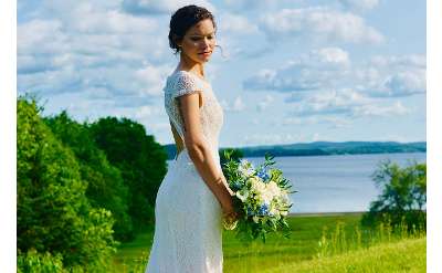 bride standing with lake in background