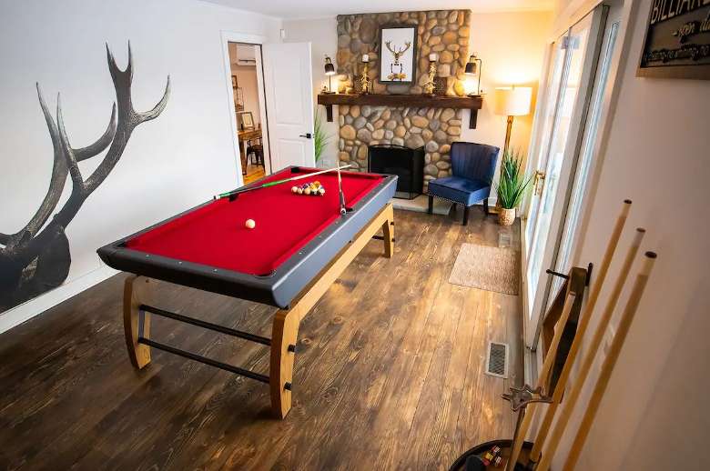 small game room with pool table and stone fireplace
