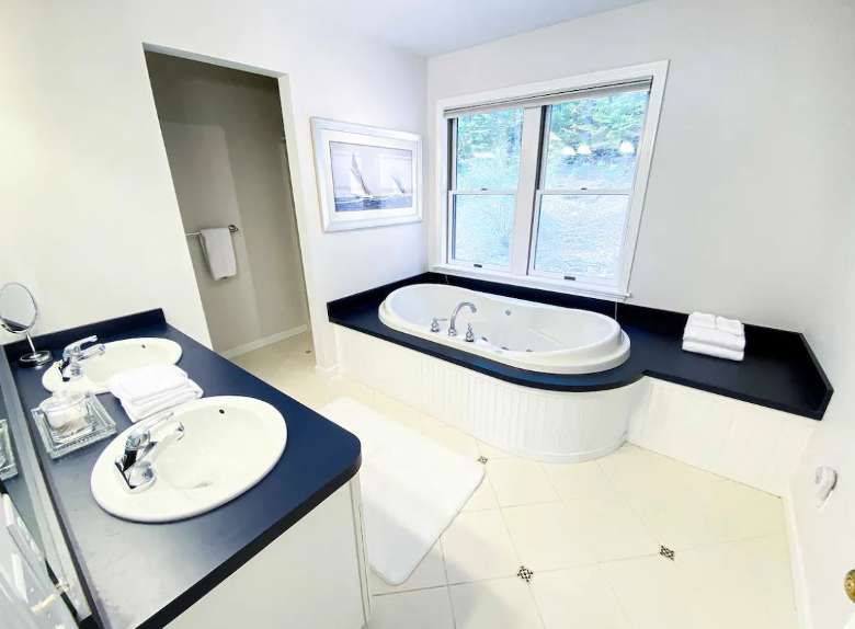 bathroom with tub and two sinks