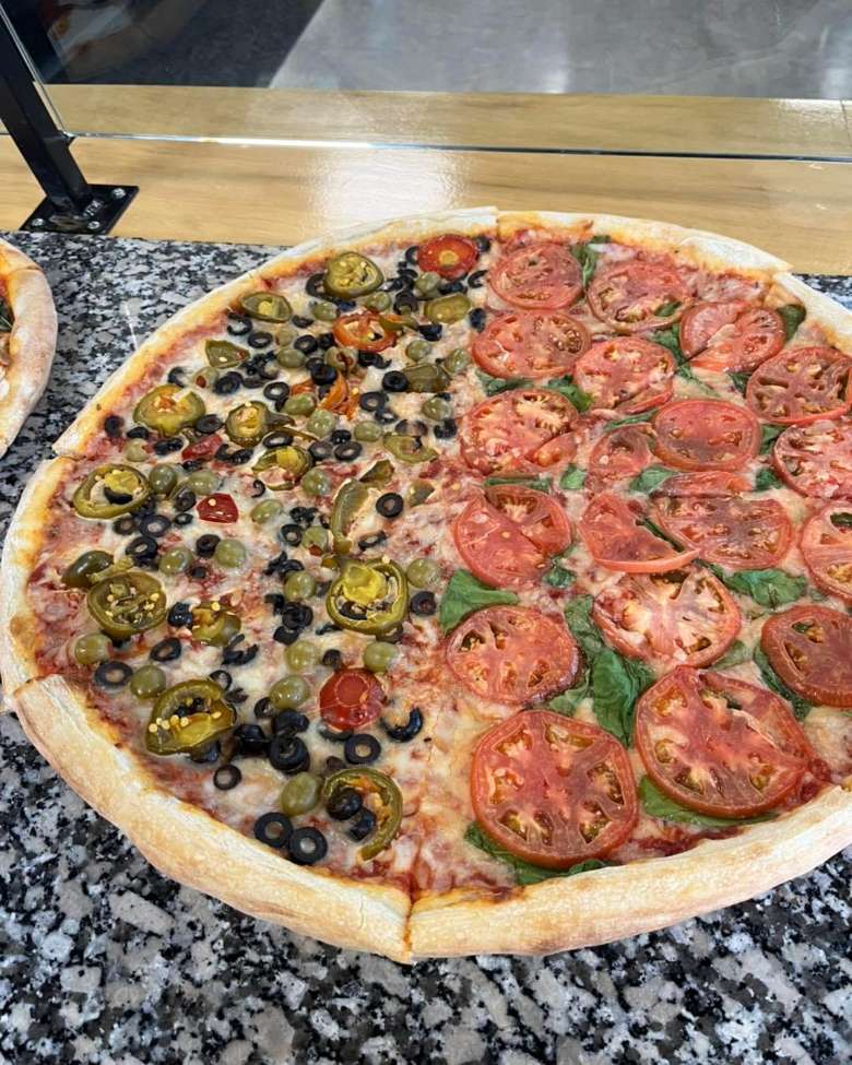 pizza with tomatoes, basil, olives, and peppers