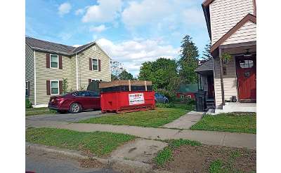 red dumpster outside of a house