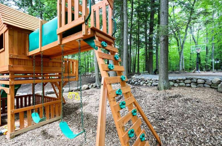 a playground with a climbing wall and swings