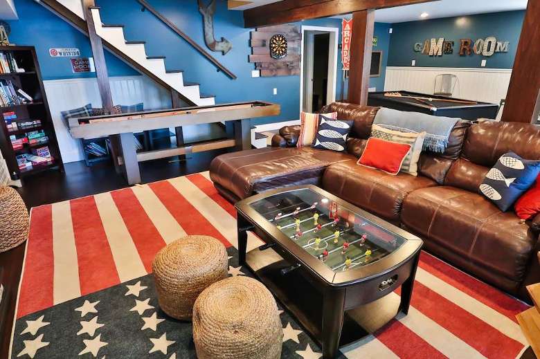 a large game room inside a house with foosball, a pool table, and other games