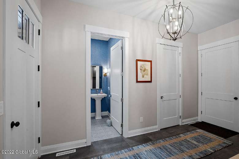 hallway in a house with white doors and a rug