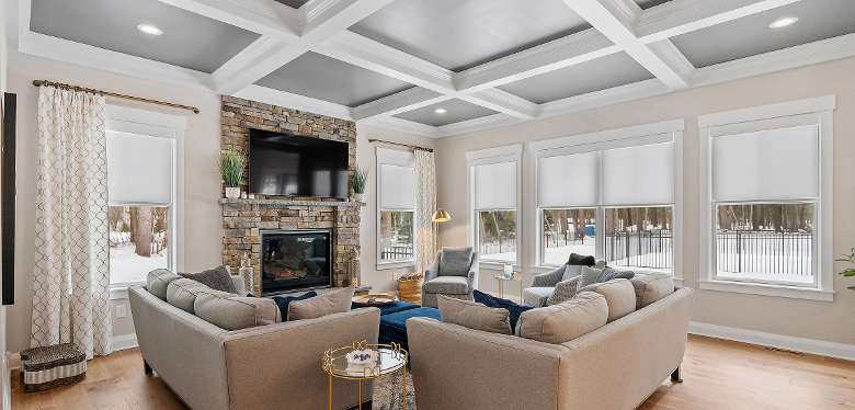large living room with a stone fireplace, couches, and windows
