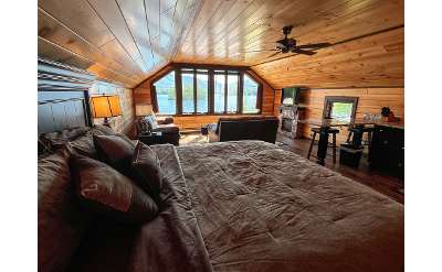 bedroom and living area with large window, lake views