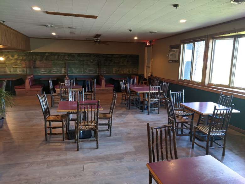 a restaurant dining room with tables and wooden chairs