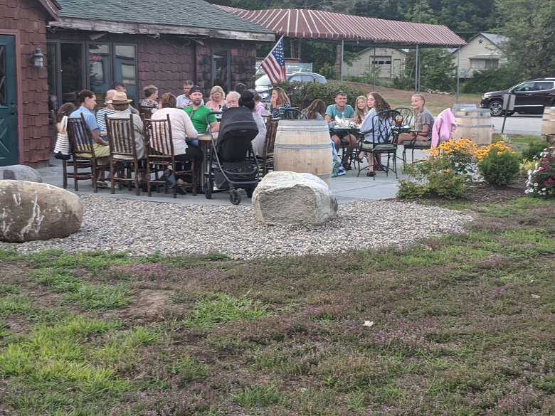 people seated at tables outside of a restaurant