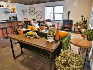 living room with chairs, a sofa, table, and a wood stove