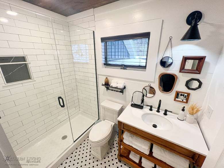 a bathroom with a glass shower, a toilet, and a sink area