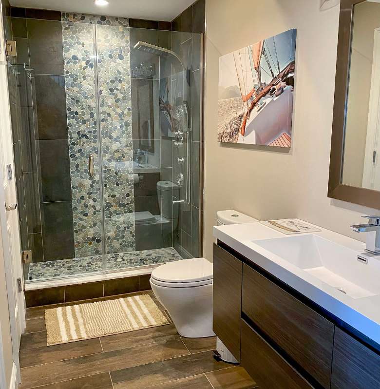 bathroom with a toilet, sink, and glass shower