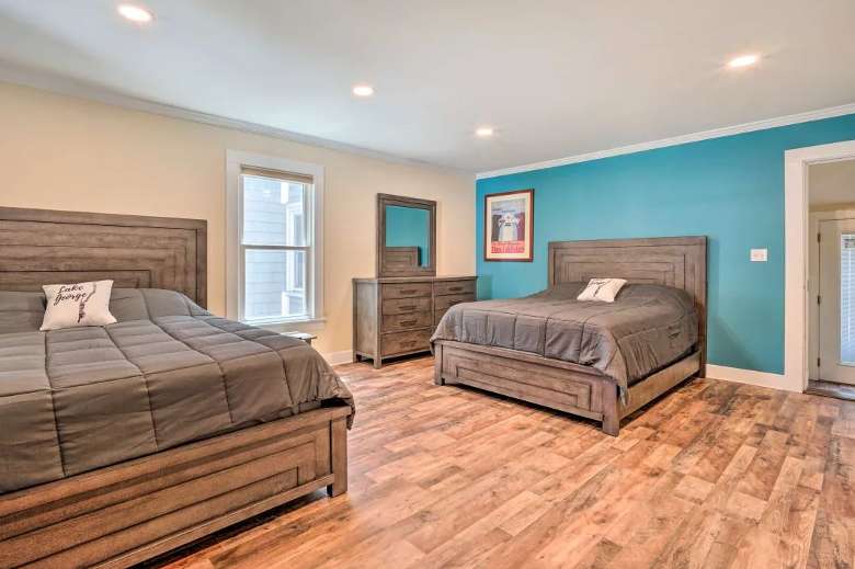 a large bedroom with wooden floors and two beds