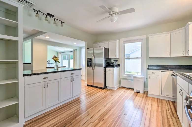 spacious kitchen with white cabinets and steel appliances
