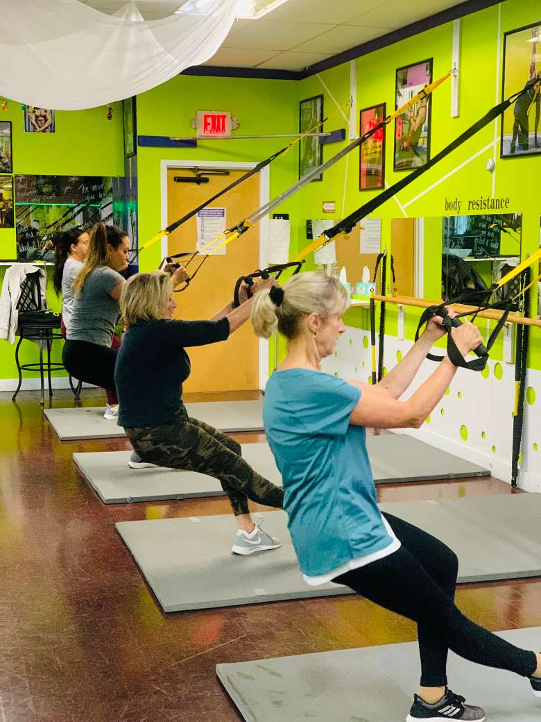 group of women doing arm exercises in a fitness facility