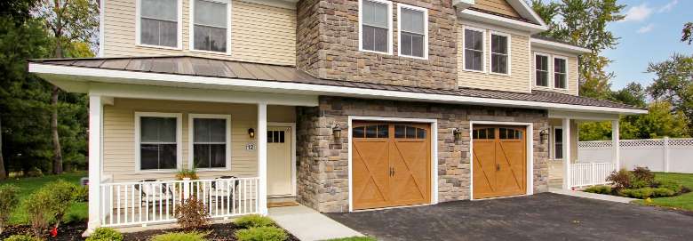 exterior of a townhome building with two garages and entrances